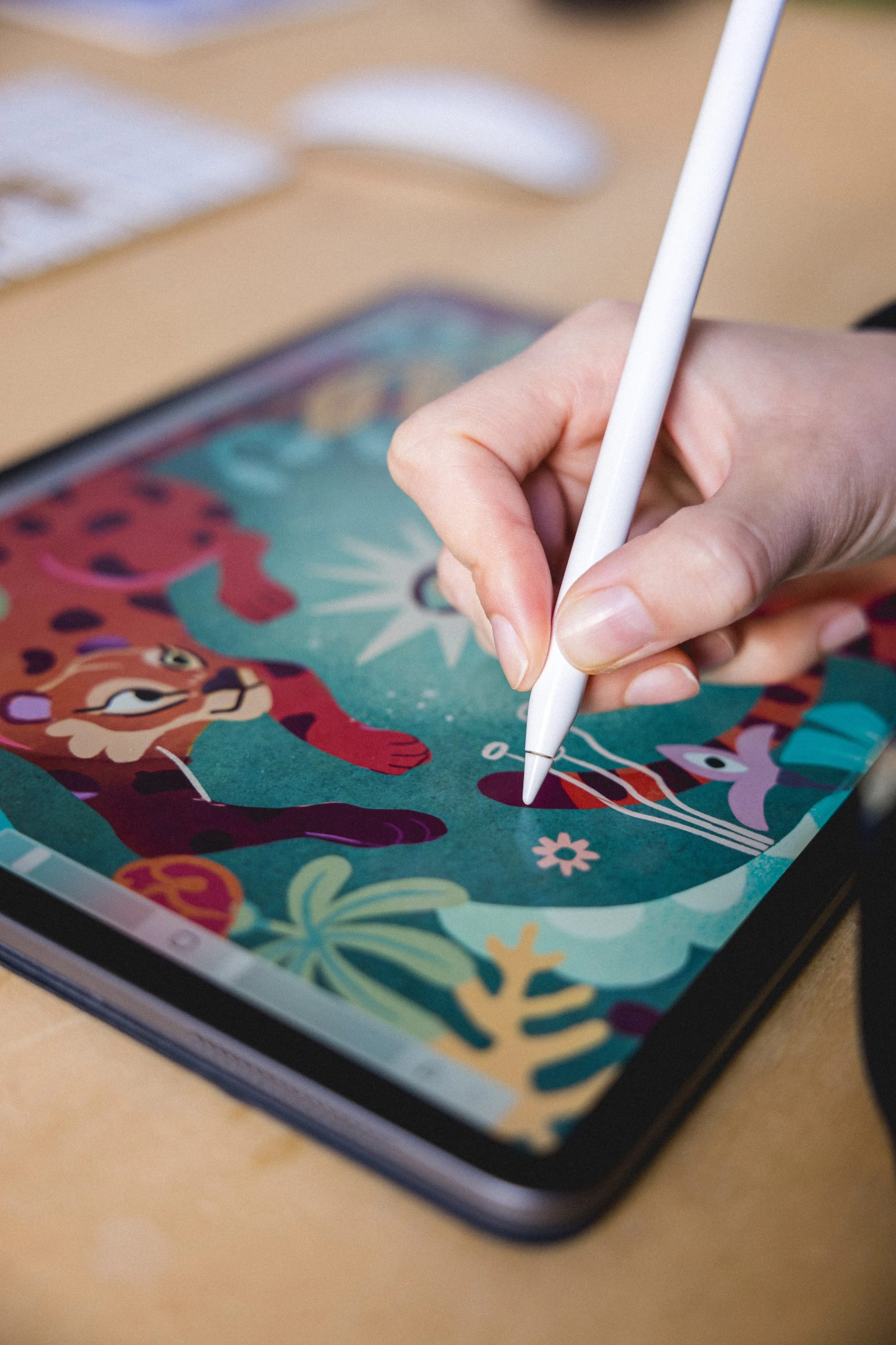 Una persona usando un lápiz óptico sobre una tableta digital que muestra personajes y plantas de dibujos animados a todo color.