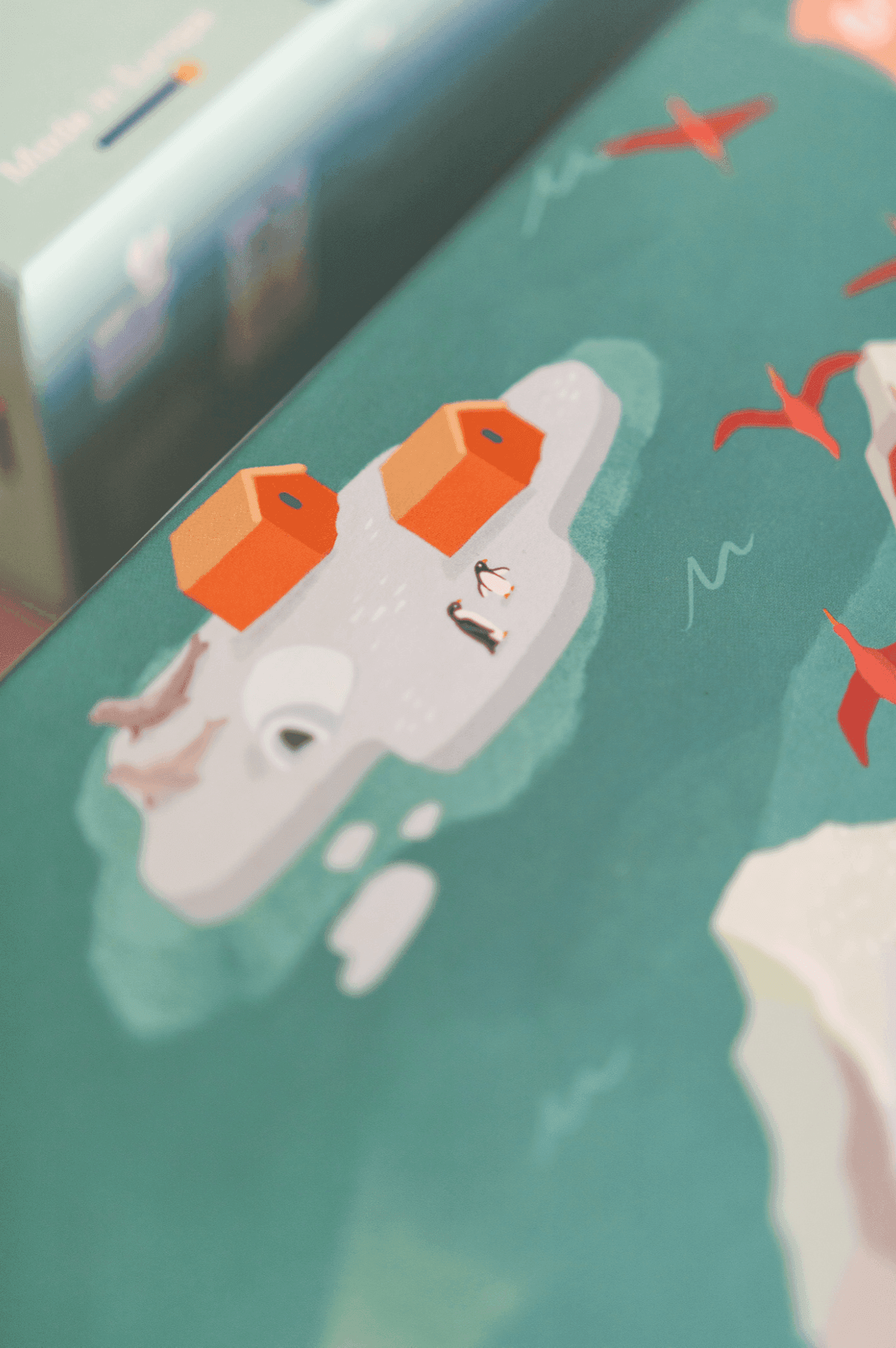 Ilustración de una isla helada con dos edificios naranjas, pingüinos y pájaros rojos en vuelo.