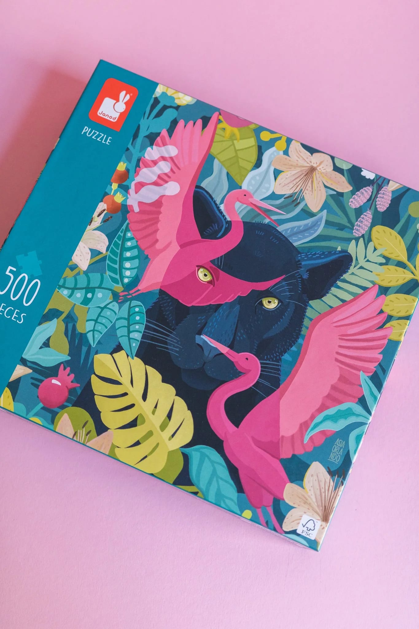 Farbenfrohe Puzzleschachtel im Dschungel-Stil mit schwarzem Panther und rosa Flamingos.