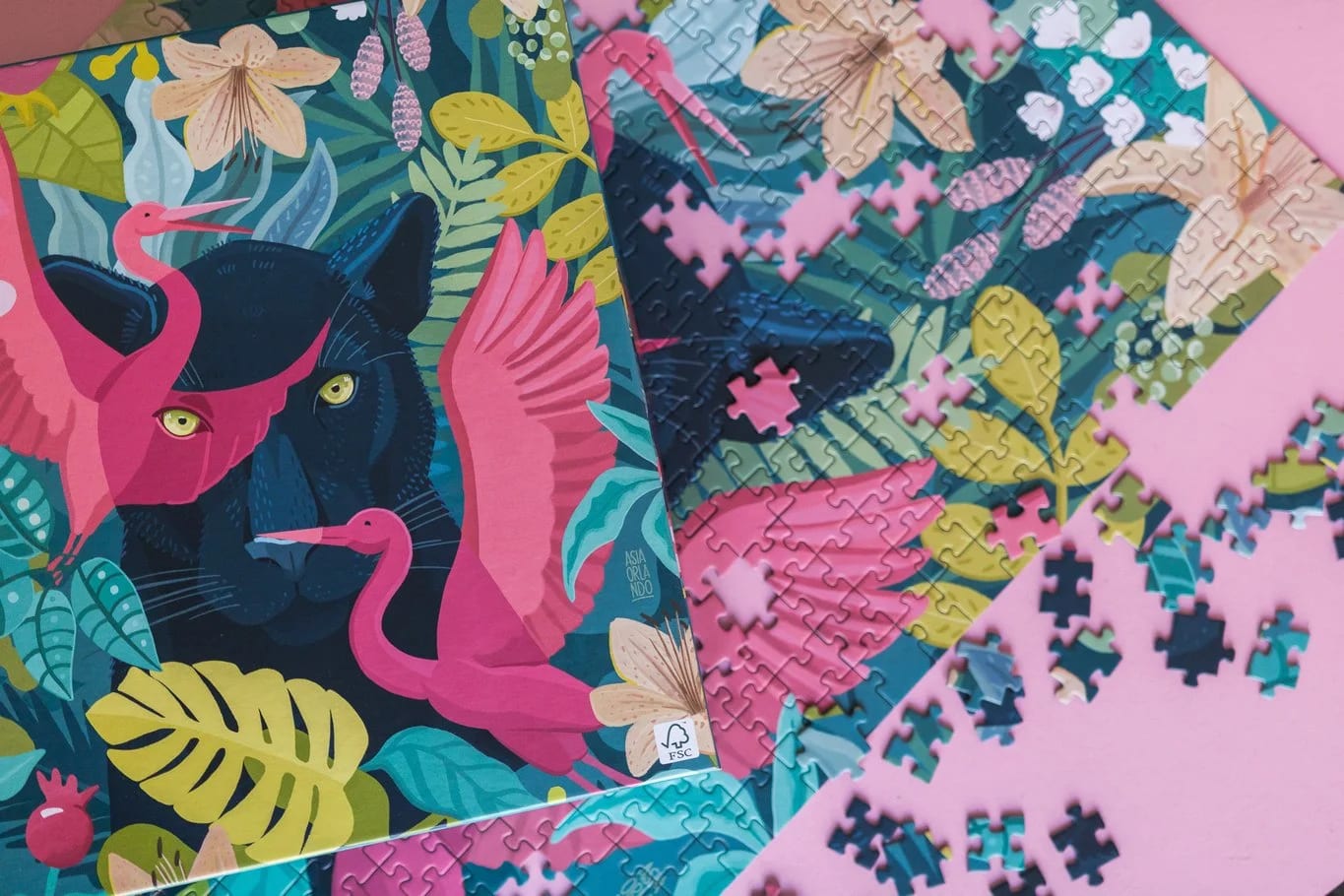 Farbenfrohes Puzzle mit tropischer Dschungelszene, rosa Flamingos, schwarzem Panther und üppigem grünem Blattwerk; einige Teile sind zusammengesetzt, andere liegen verstreut.