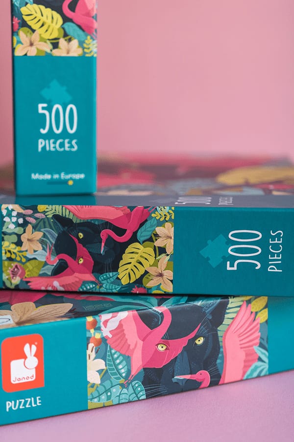 Puzzleschachteln mit Motiven tropischer Tiere und Pflanzen, jeweils mit 500 Teilen, eine Schachtel zeigt einen Flamingo und einen Panther zwischen Blättern und Blumen.