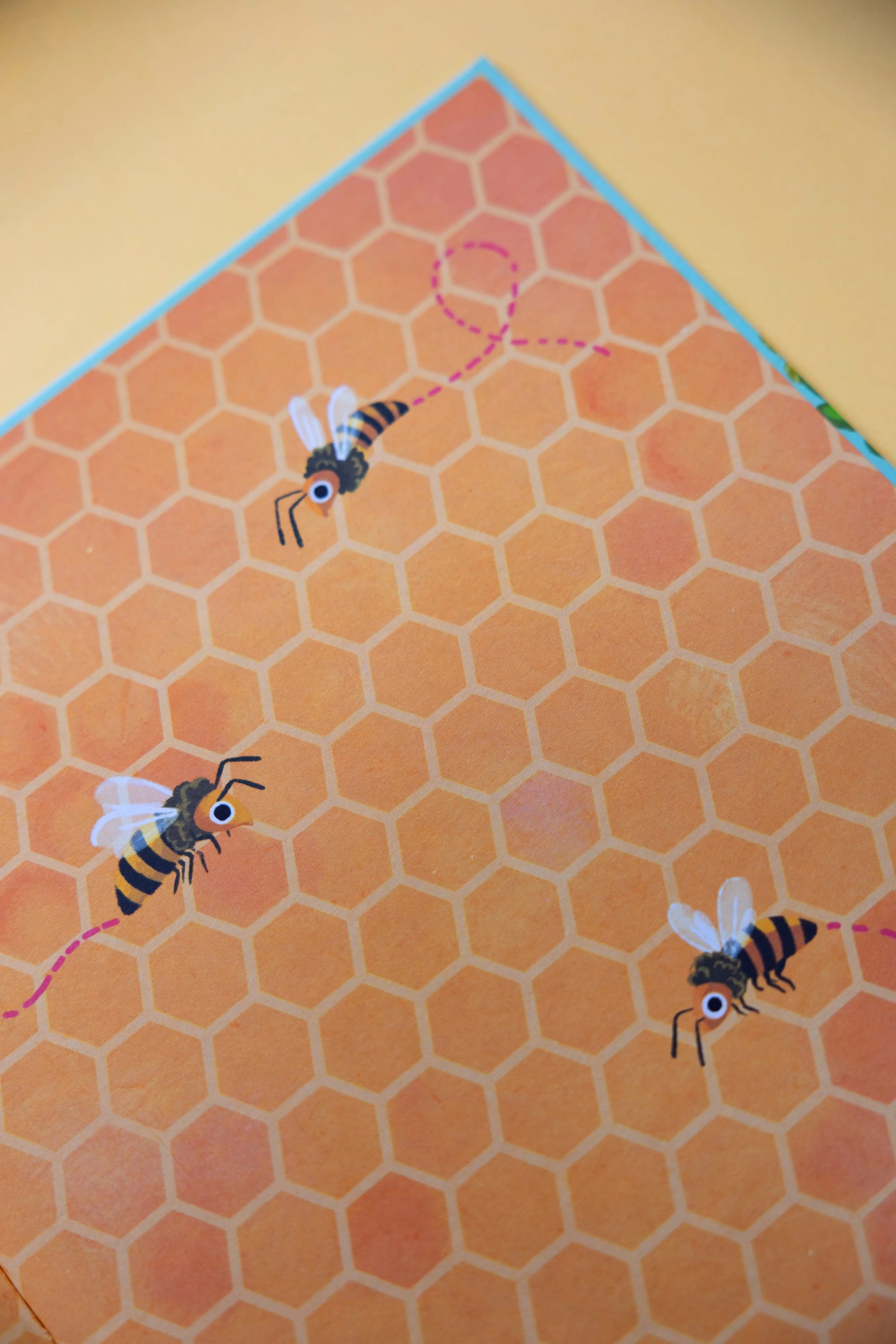 Illustration von Bienen mit Wabenhintergrund und rosa gestrichelten Flugwegen.